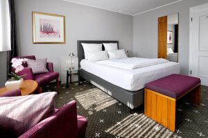 Komfortzimmer: Raumansicht mit Doppelbett und Sitzgelegenheit im stilvollen Design
